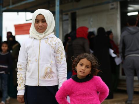 Two girls in an Iraq camp outside a health clinic